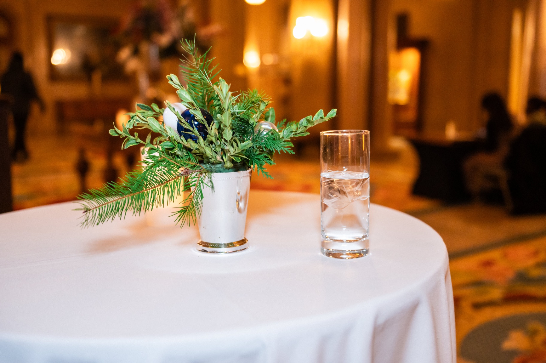 Reception table styling with floral centerpiece and water glass at the gala