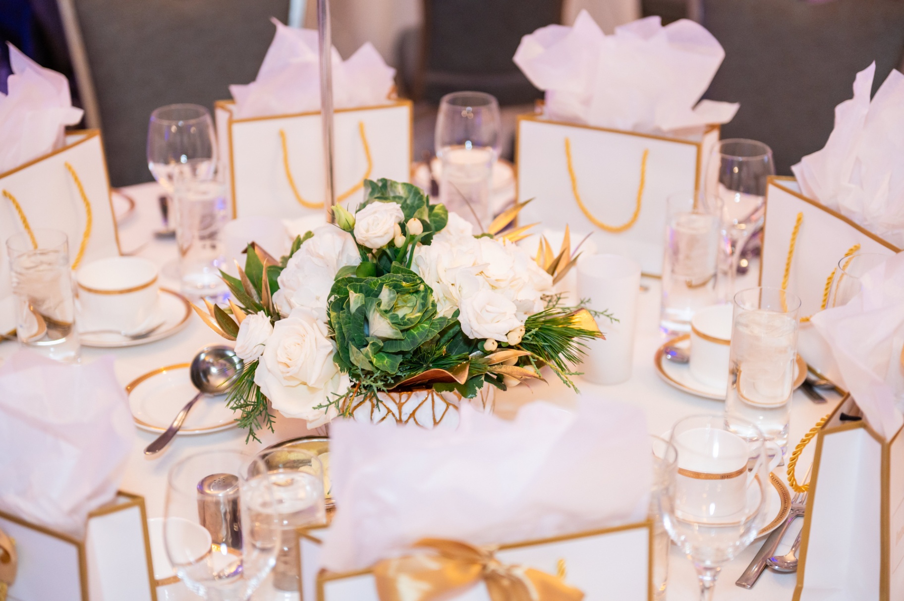 Close-up of the white rose and greenery centerpiece on a gala table
