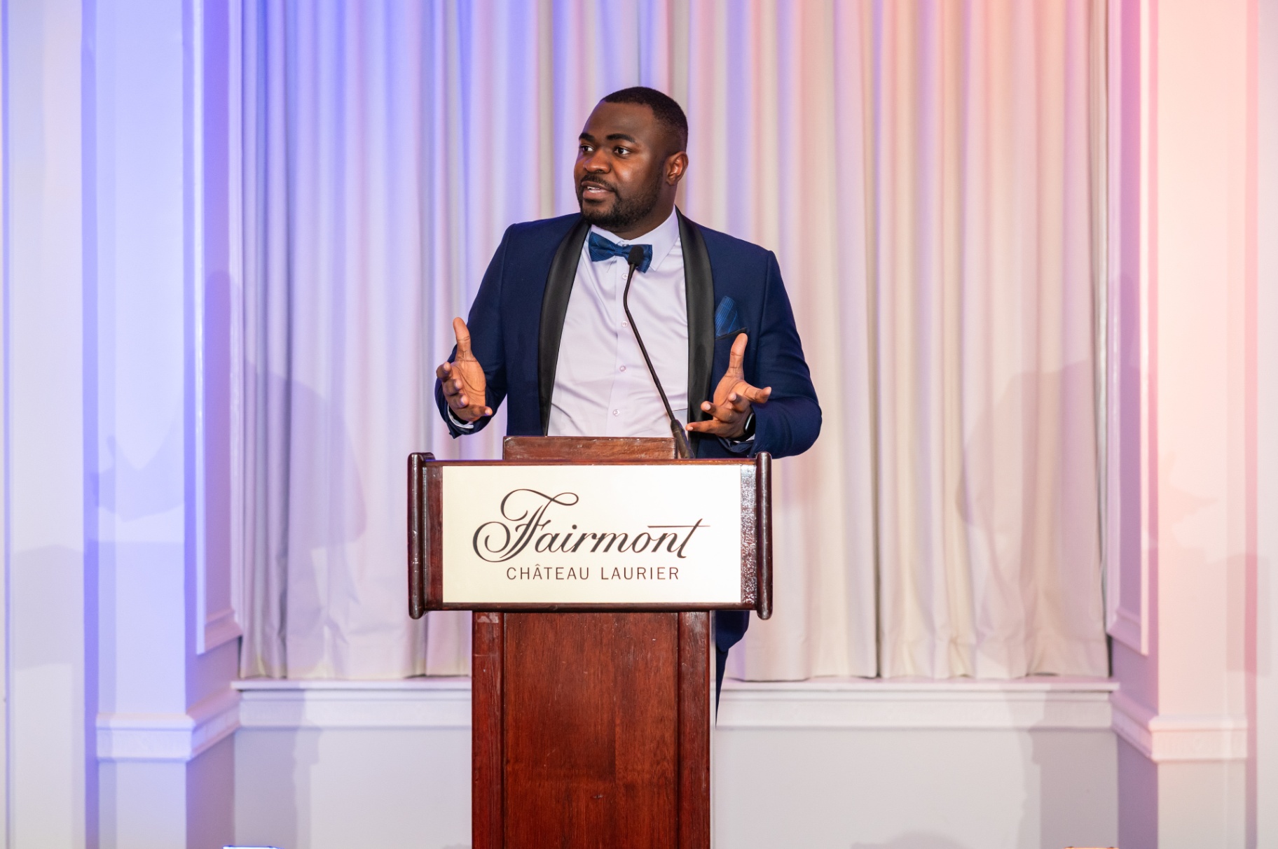 Speaker gesturing while addressing guests from the gala podium