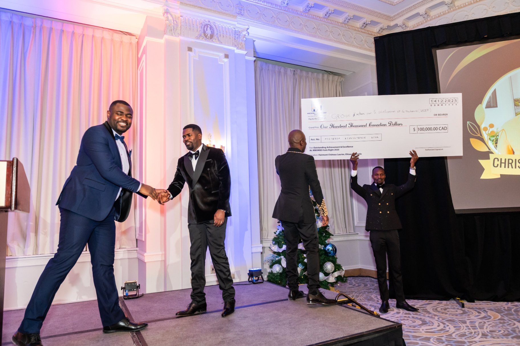 Handshake celebration as the ceremonial cheque is lifted during the gala