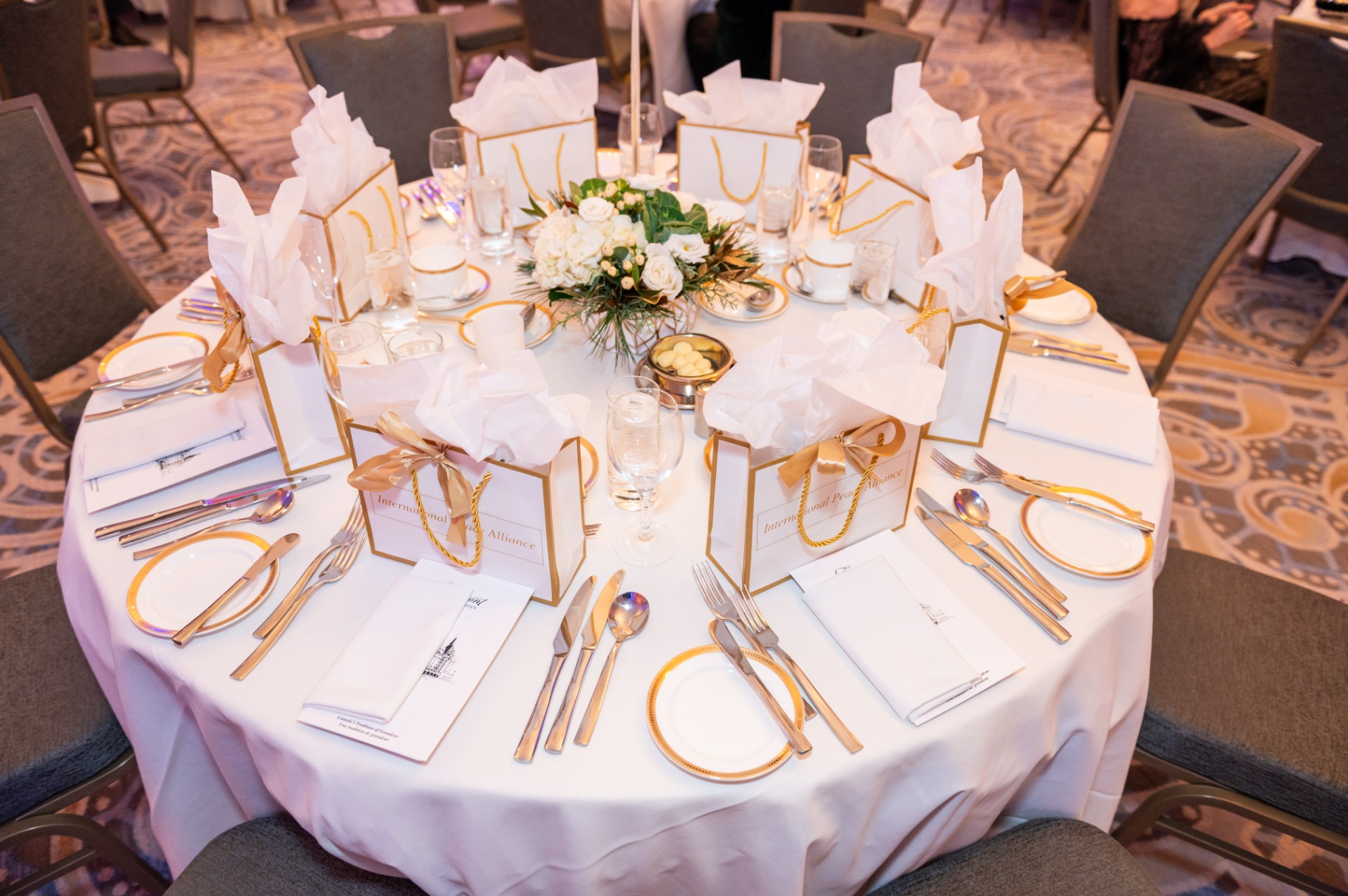 Overhead view of an elegantly set gala table with gold-rimmed china and floral centerpiece