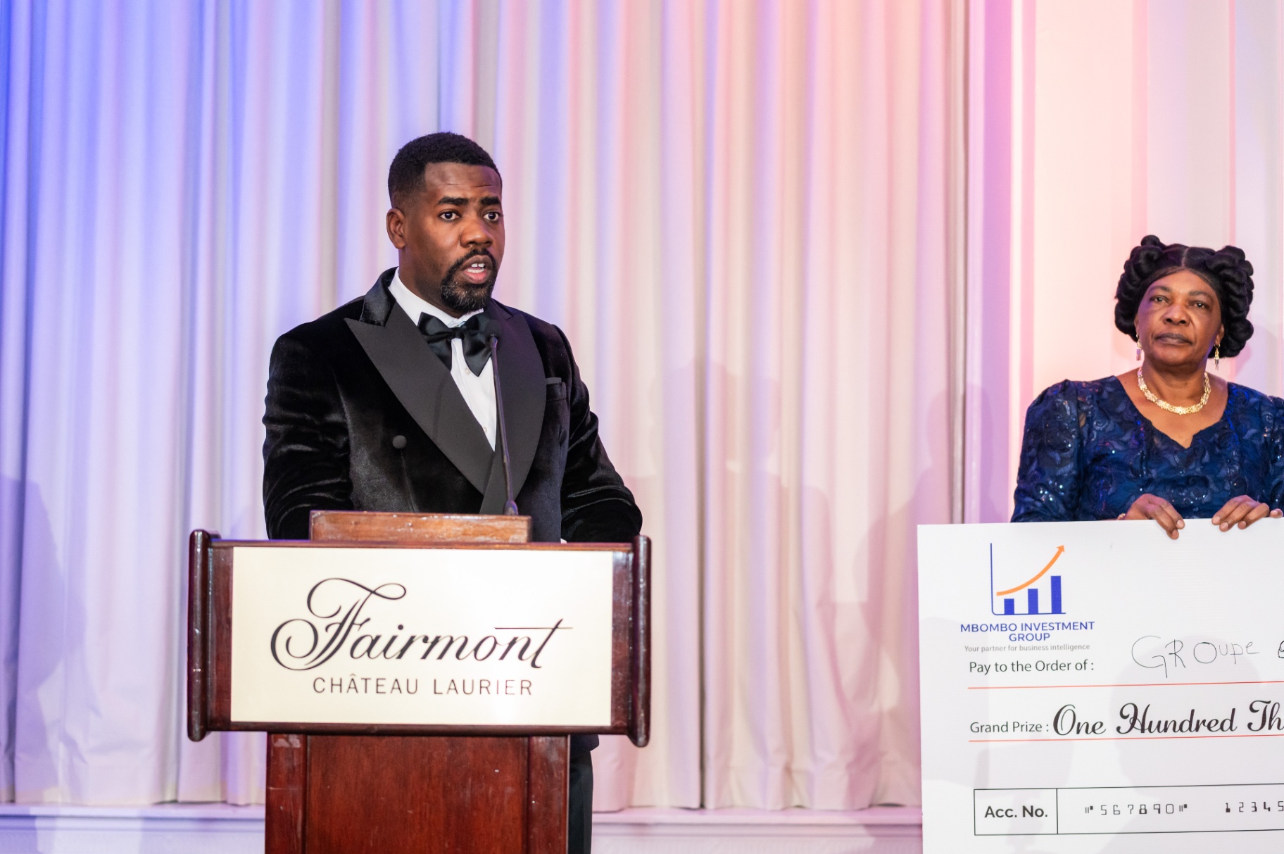 Host at the Fairmont Château Laurier podium beside the CA$100,000 Grand Prize cheque