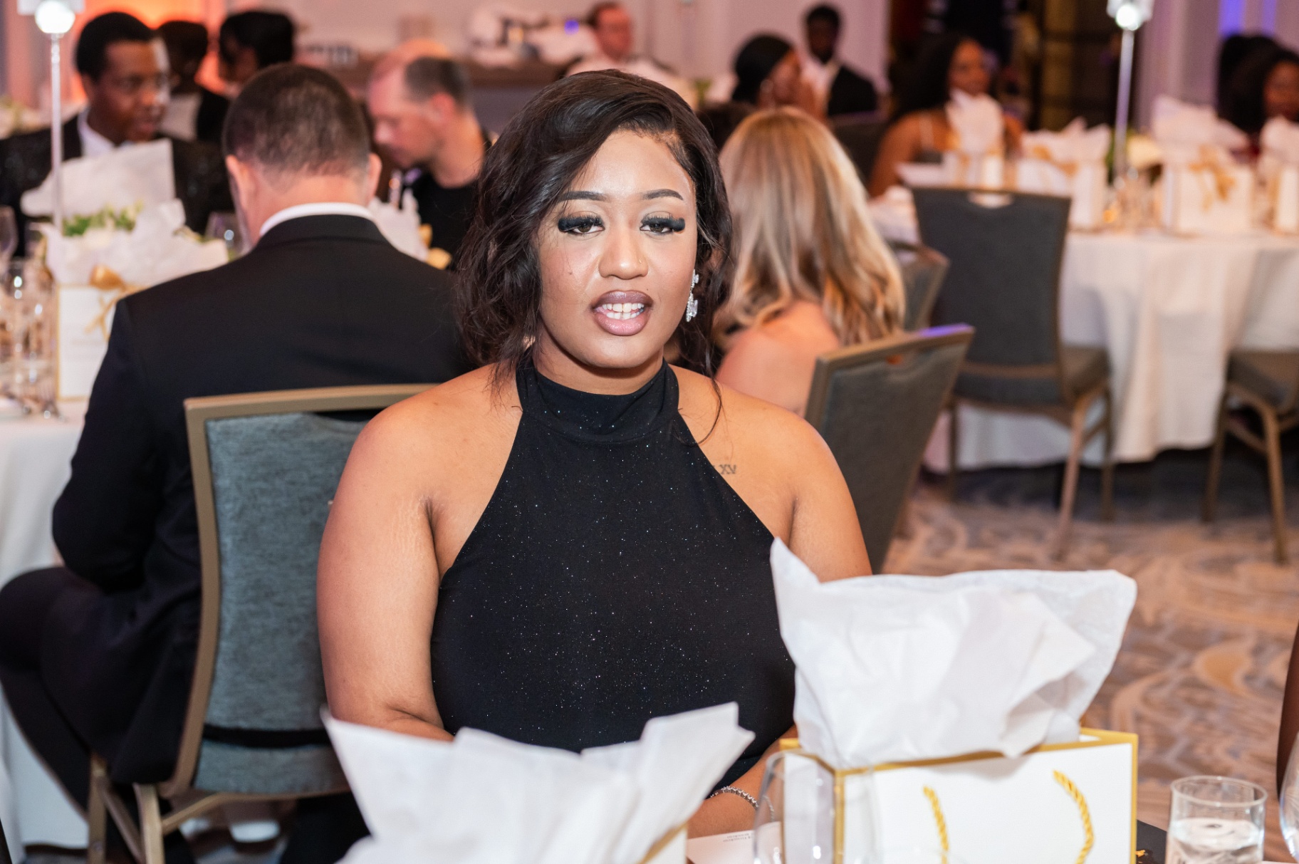 Guest in a black sparkling halter gown at the gala dinner