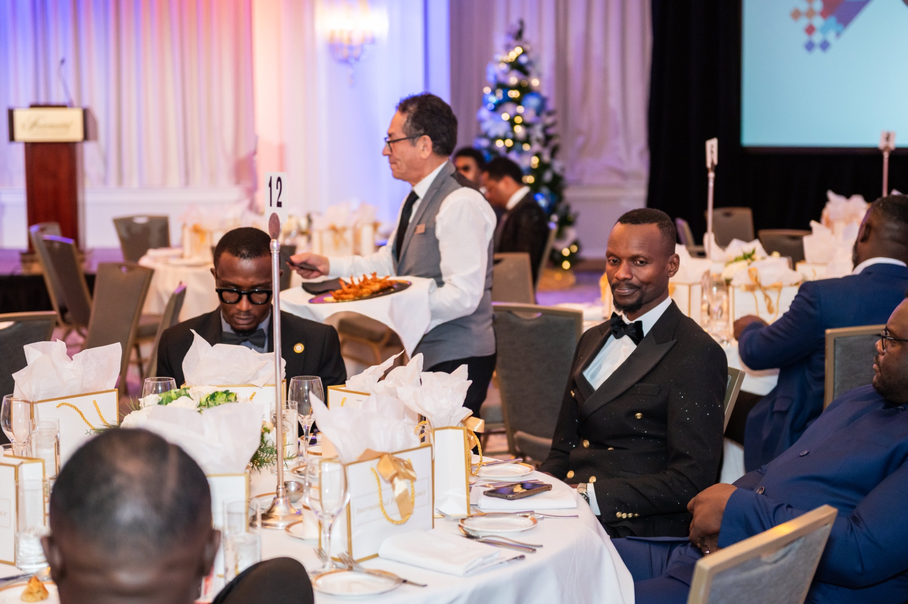 Guests in formal attire seated at table 12 during the gala evening