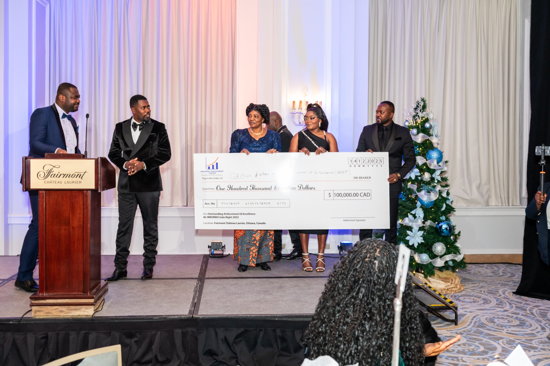 Mbombo Investment Group presenters with the ceremonial cheque on stage