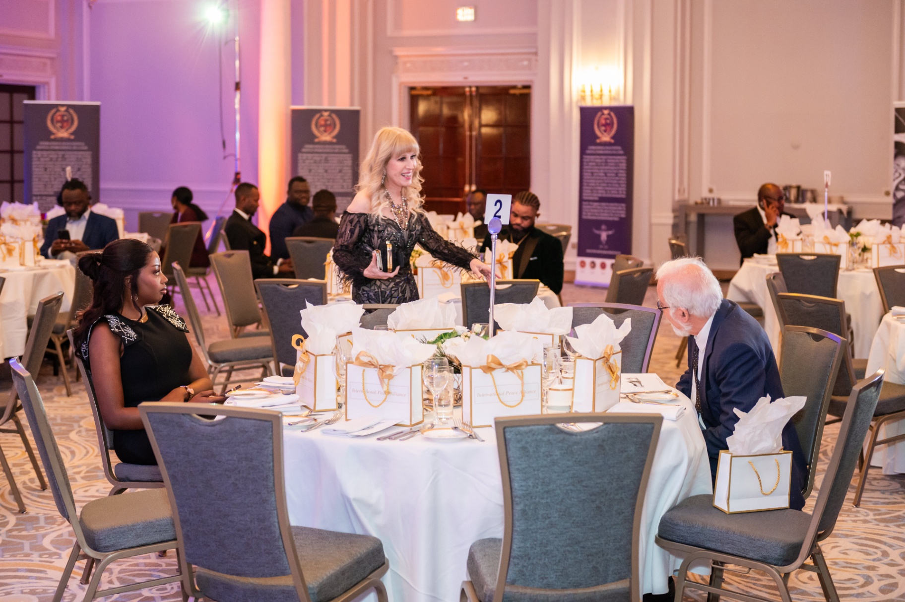 Host welcoming guests at table 2 during the Mbombo Gala Night reception