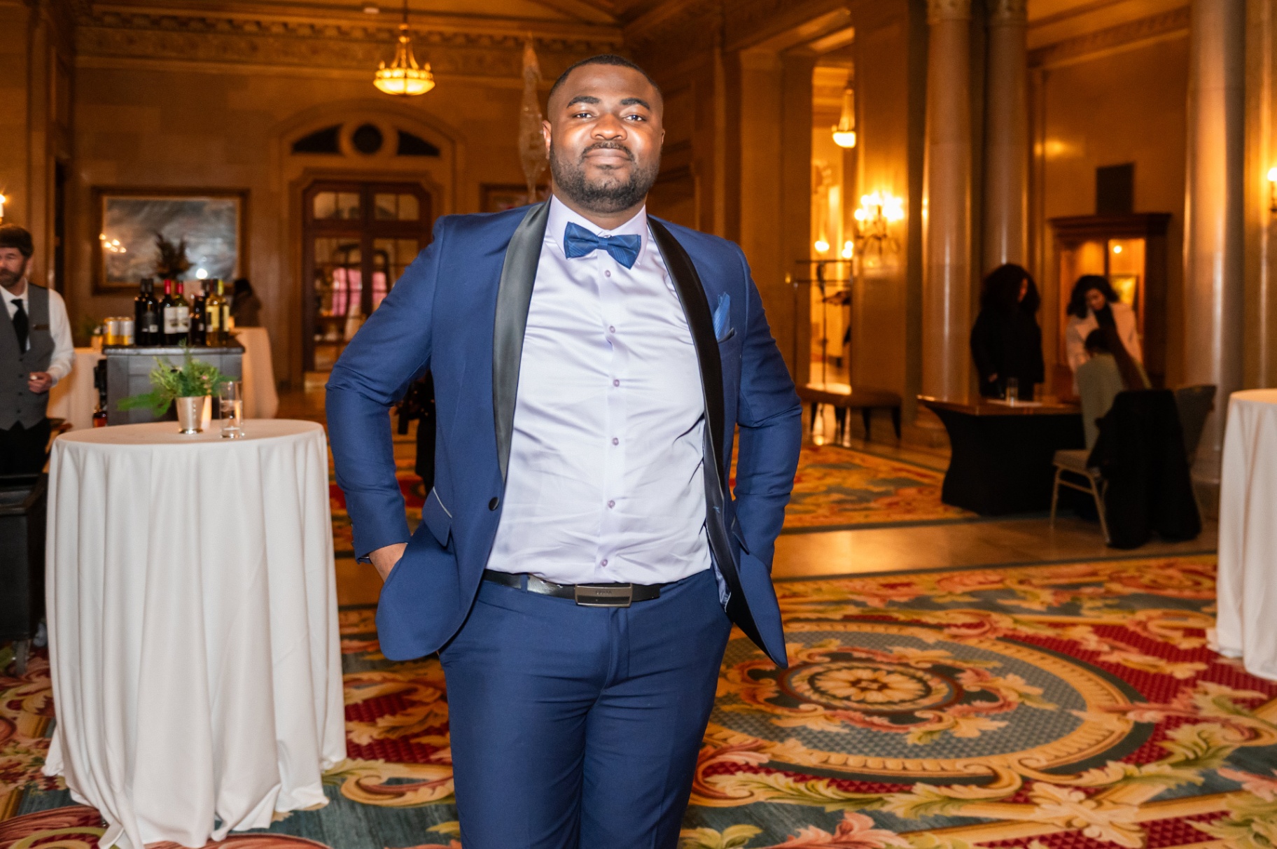Guest in royal blue tuxedo with bow tie posing in the Fairmont ballroom