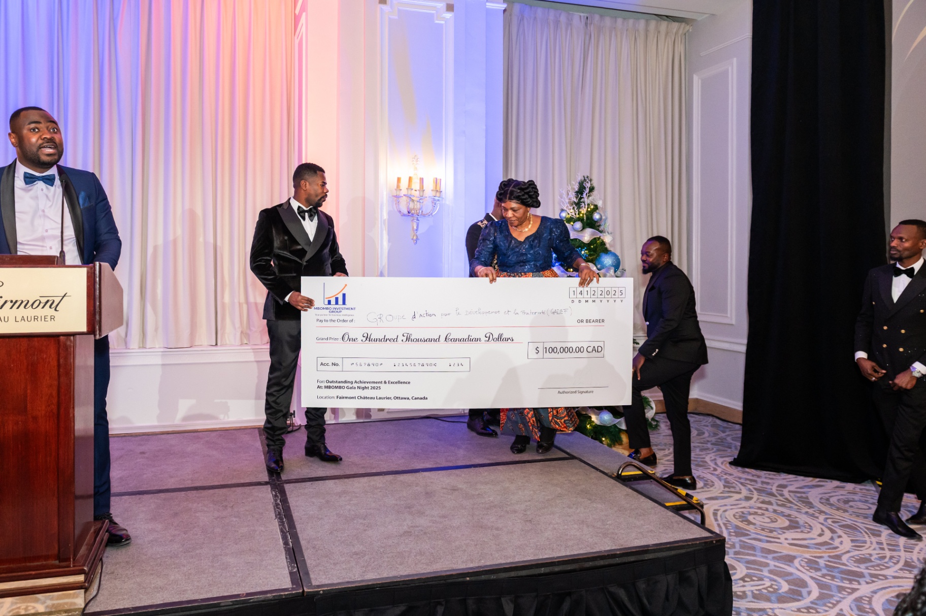 Speaker at the podium while the grand prize cheque is moved into place