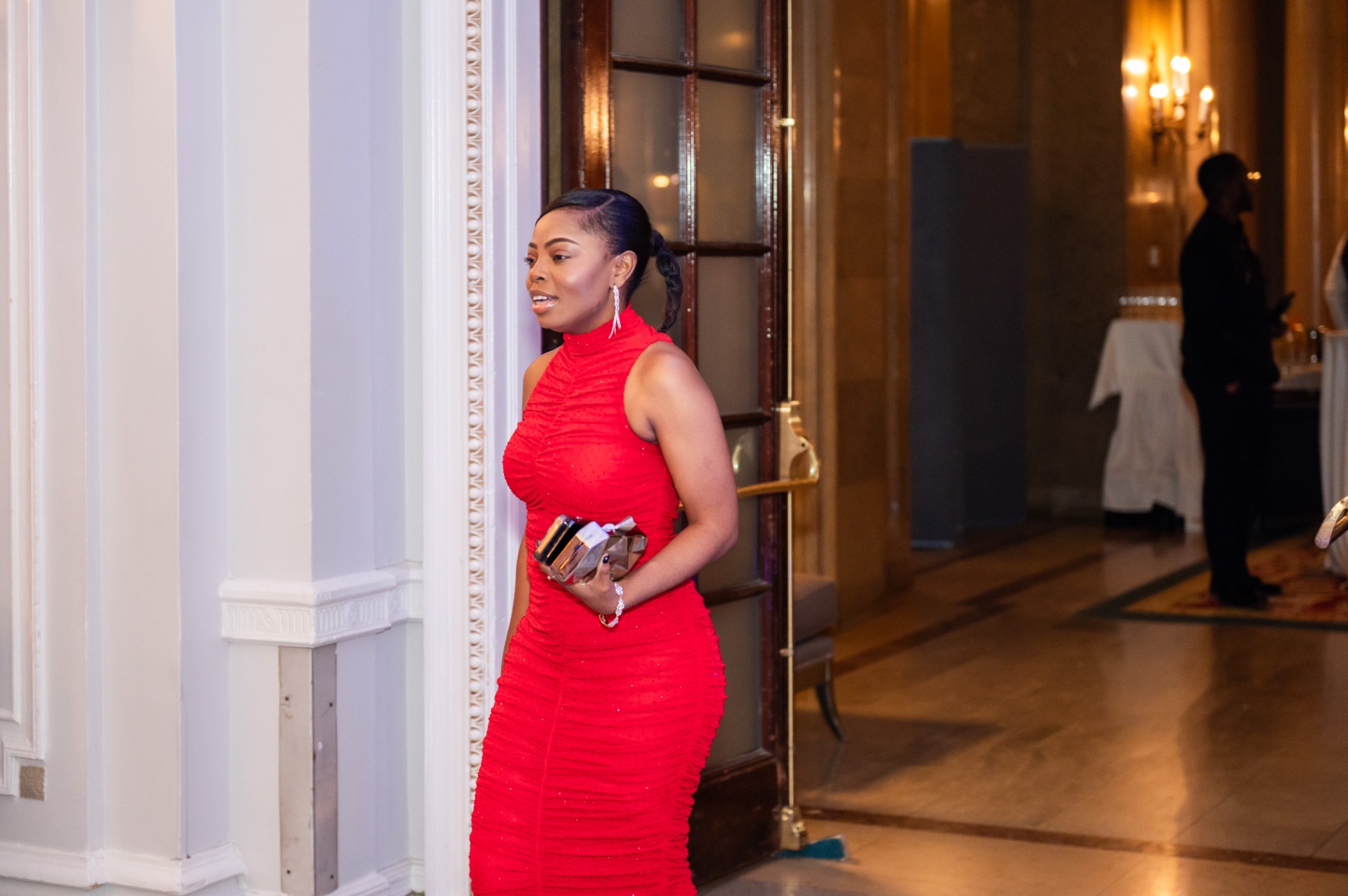 Guest in a bright red evening gown arriving at the gala reception