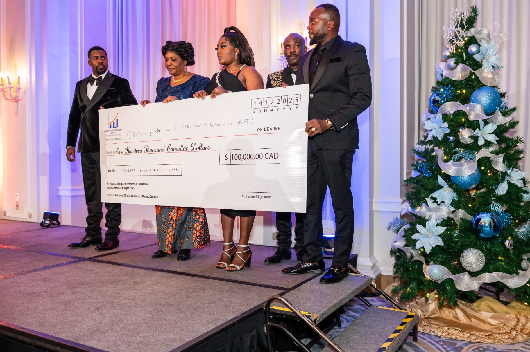 Close-up of the CA$100,000 ceremonial cheque presentation beside the Christmas tree