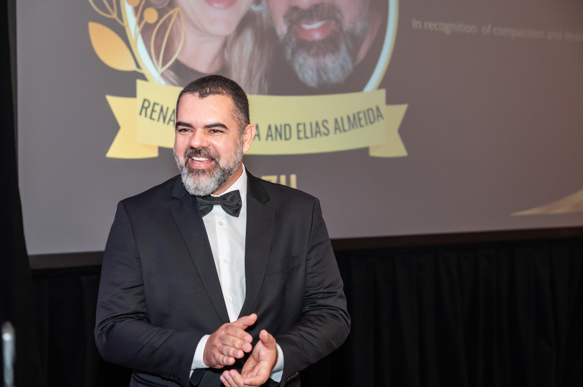 Elias Almeida acknowledging the Humanitarian Impact Award on stage
