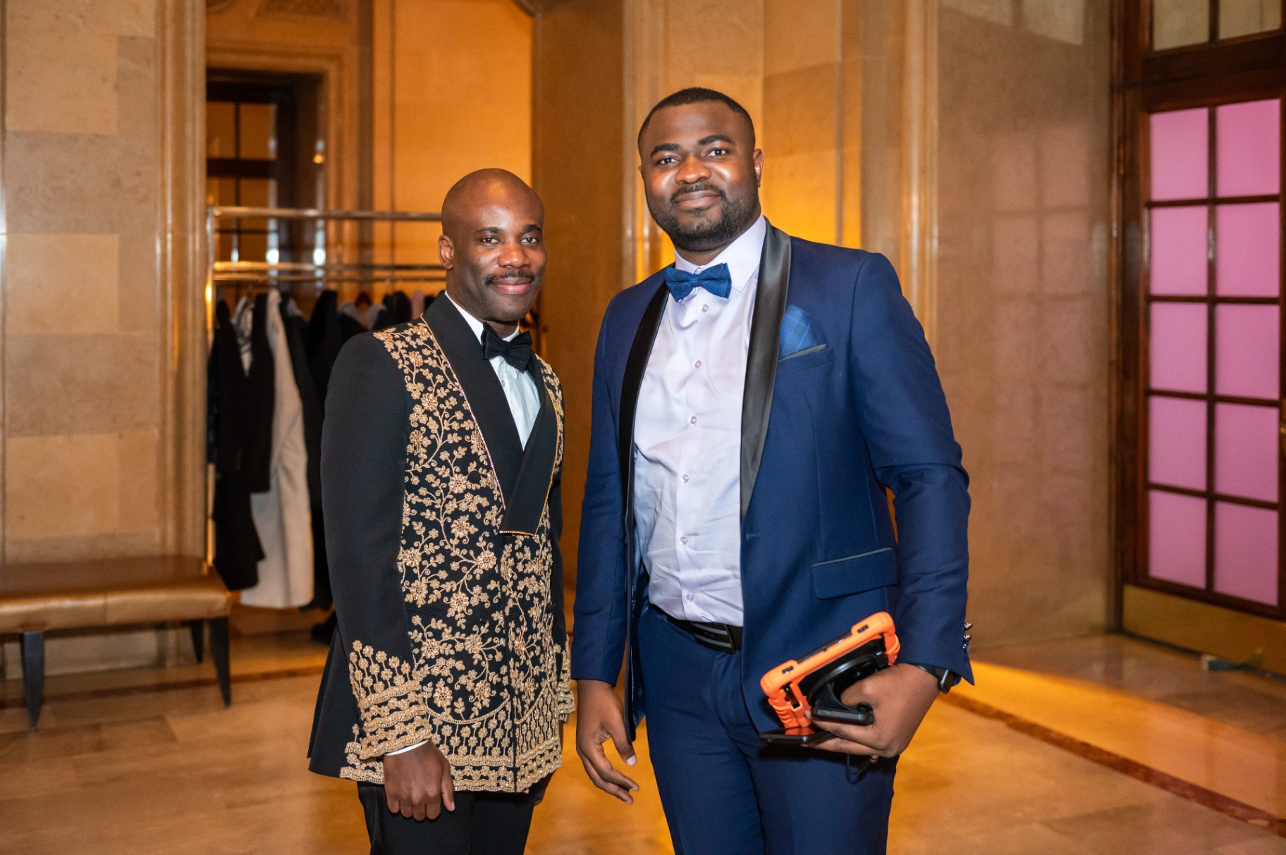 Portrait of two guests in embroidered black-and-gold and blue formal attire
