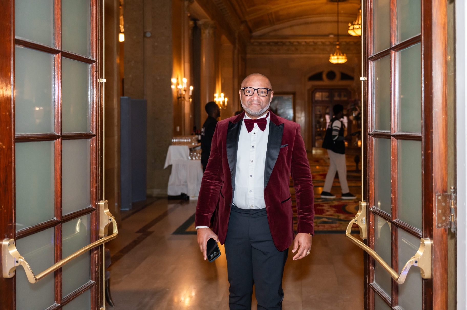Guest in burgundy velvet tuxedo entering through the Fairmont Château Laurier doors
