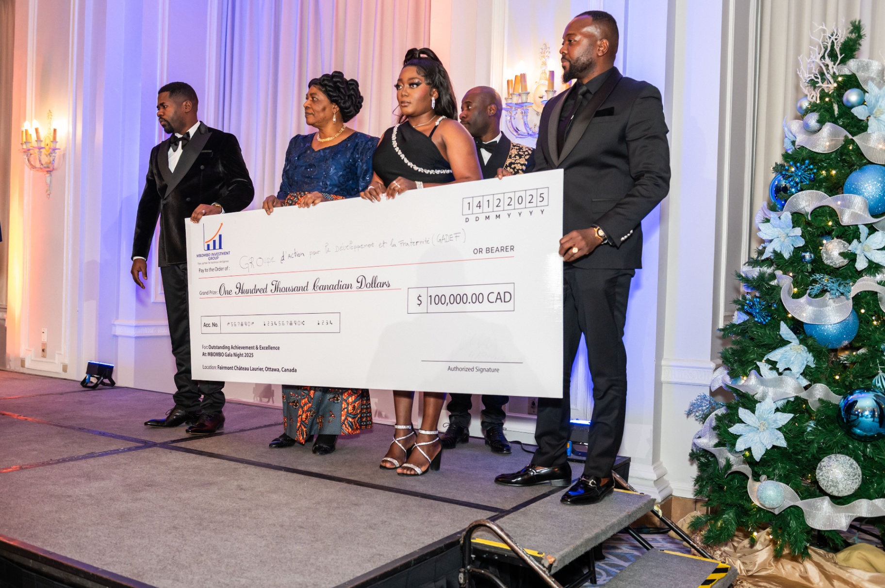 Award team holding the One Hundred Thousand Canadian Dollars cheque