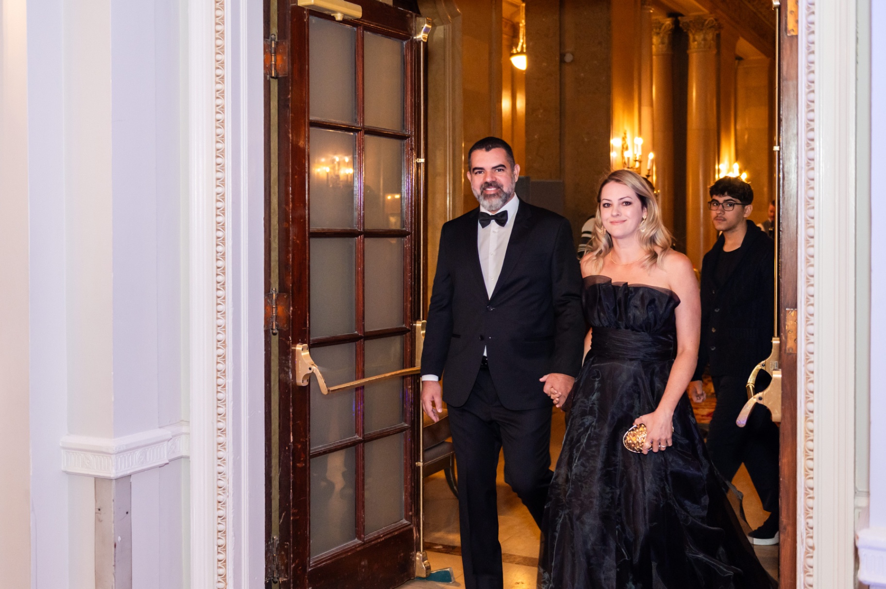 Couple in black-tie attire arriving through the Fairmont Château Laurier doorway